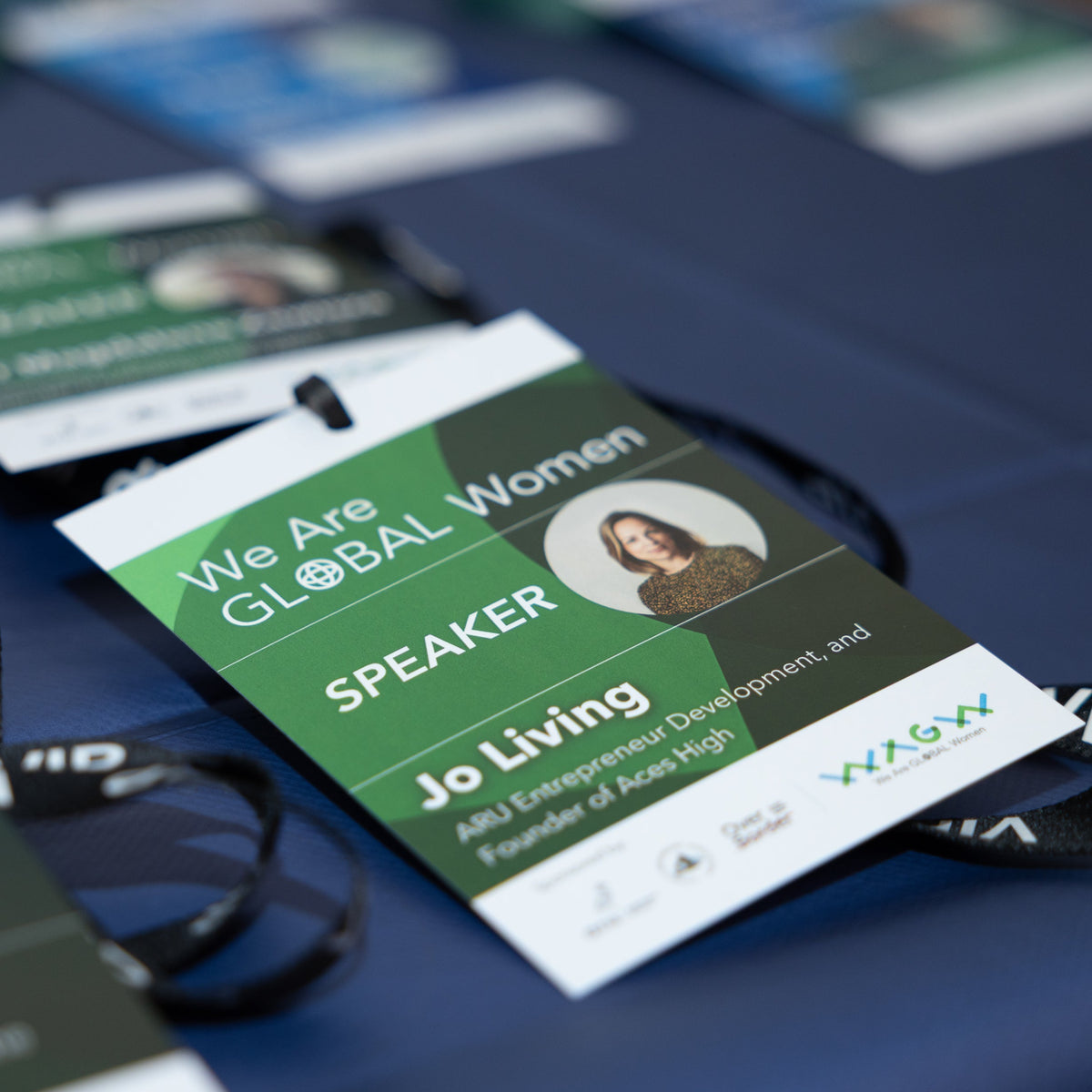 Speaker card for Global Women event on a table with blurred background